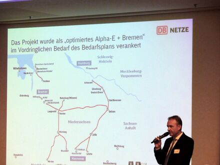 Projektleiter Matthias Hudaff mit Mikrophon vor einer Präsentation
